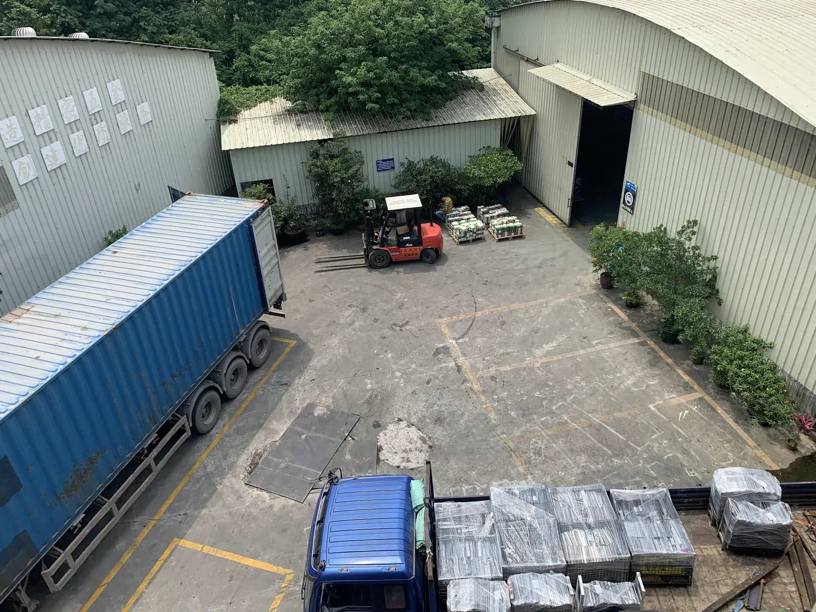 Forklift and vehicles in the shipment loading area at the manufacturing site